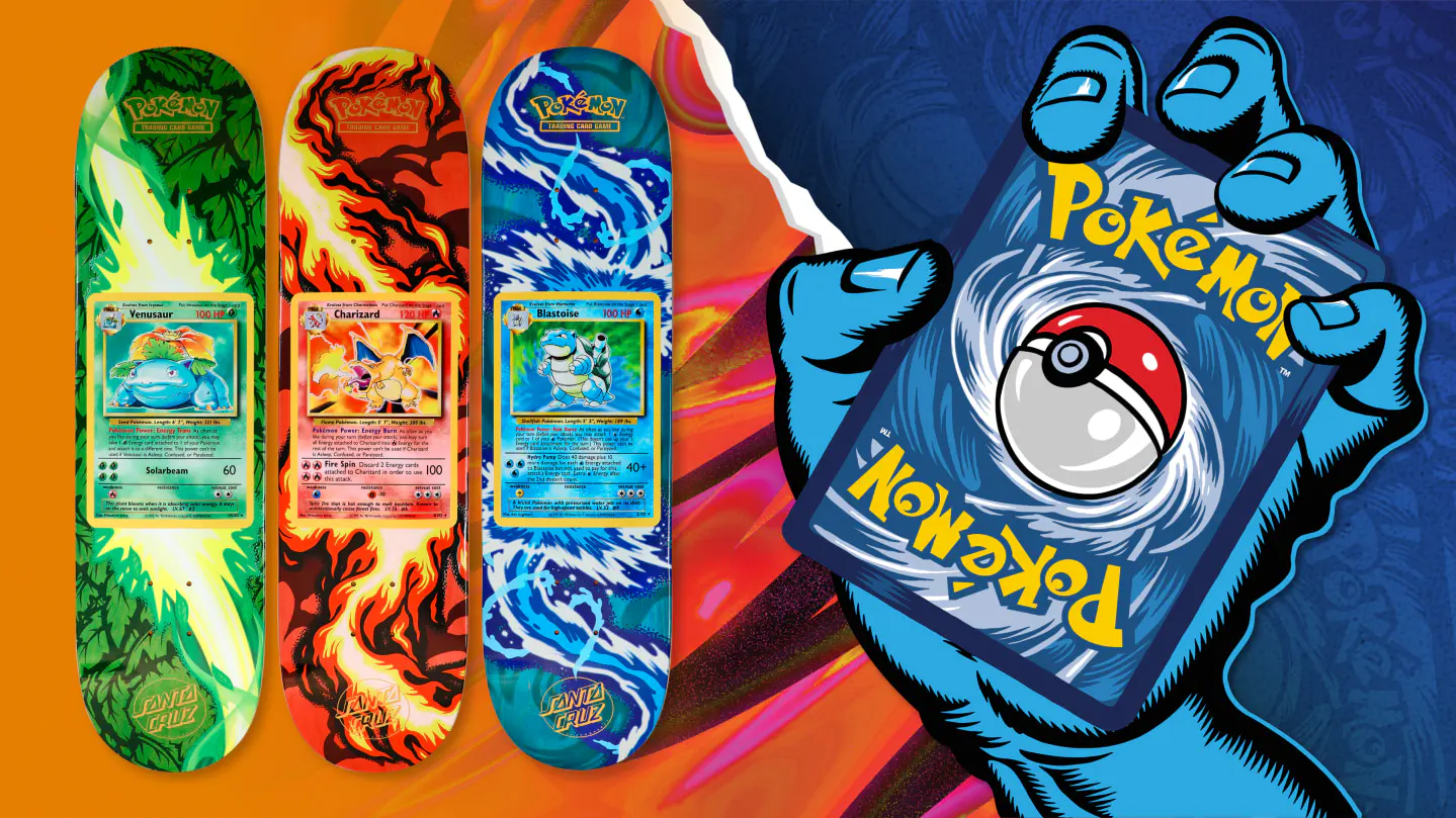 Three Pokémon TCG Santa Cruz skateboard decks showing Venusaur, Charizard and Blastoise cards beside a blue hand holding a Pokémon card back